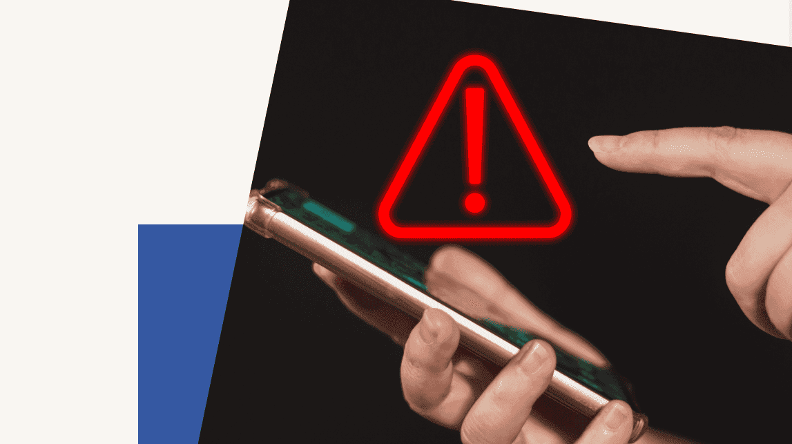 Main avec un téléphone portable. Un point d'exclamation annonce une alerte