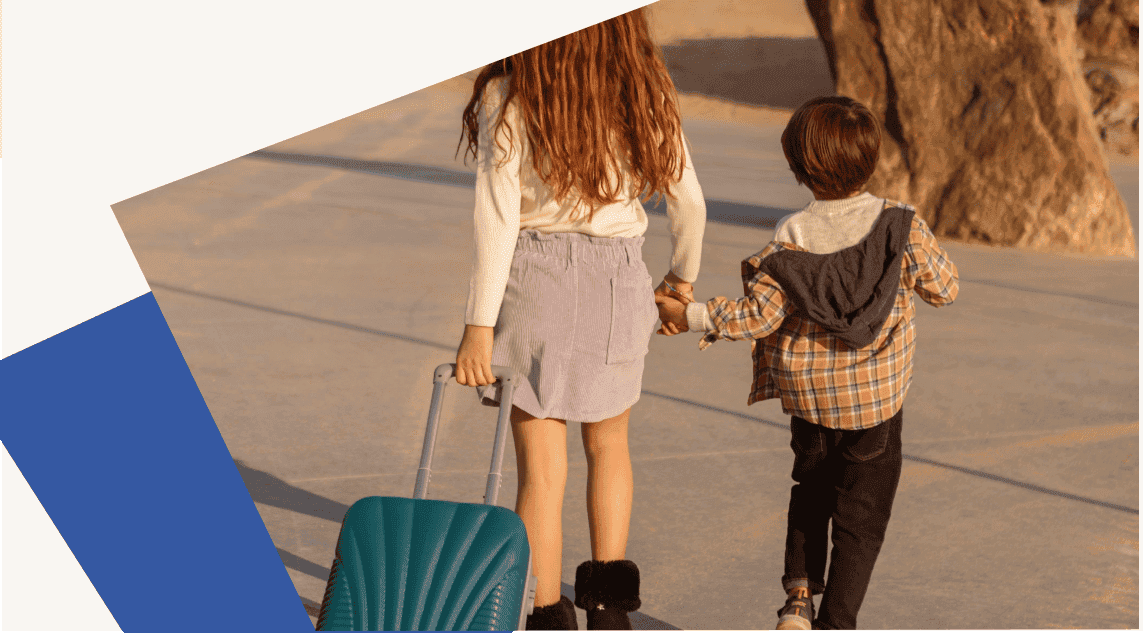 Photo de deux jeunes personnes de dos marchant avec une valise