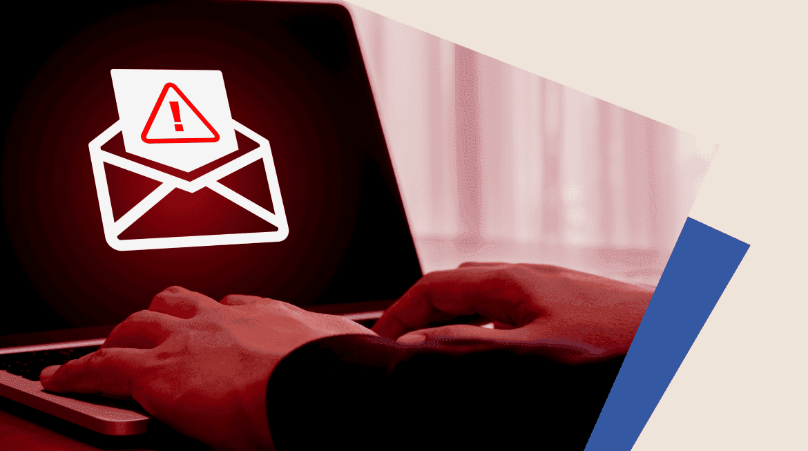 Mains devant un ordinateur. Sur l'écran, une alerte est affichée sur un email